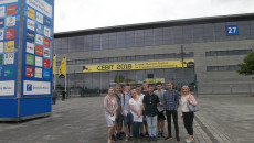 Grupa młodych osób pozuje do pamiątkowej fotografii przed halą targów CEBIT 2018 w Hanowerze