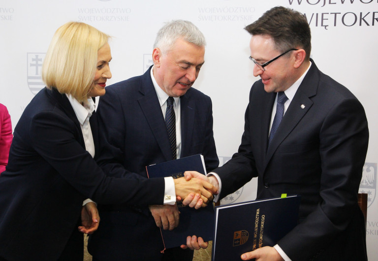 Marszałek województwa świętokrzyskiego Andrzej Bętkowski i wicemarszałek Renata Janik gratulują dyrektorowi Głównego Urzędu Miar Andrzejowi Hantzowi