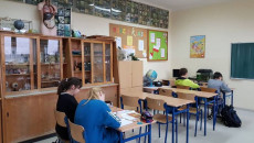 Uczniowie siedzący w klasie w ławkach