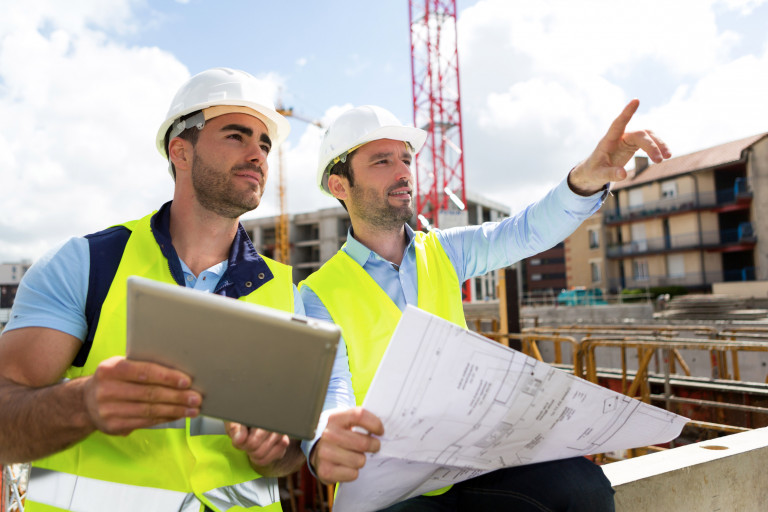 Worker And Architect Watching Some Details On A Construction