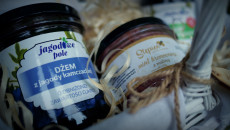 słoiki z dżemem owocowym leżące na słomie na festiwalowym stoisku