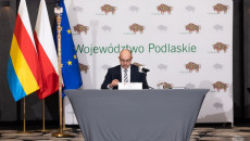 Marszałek Województwa Podlaskiego Artur Kosicki, siedząc za stołem prowadzi posiedzenie konwentu marszałków województw rp