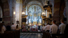 Wnętrze kościoła w trakcie mszy świętej, wierni stoją w ławkach