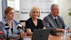 Trzy osoby siedzą za stołem. Obok wiceminister Olgi Semeniuk siedzi Renata Janik, wicemarszałek województwa