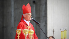 Ksiądz biskup Marian Florczyk ubrany w szaty liturgiczne koloru czerwonego stoi przy ołtarzu, przewodnicząc mszy świętej