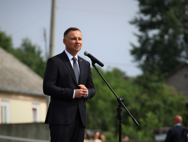 Prezydent Andrzej Duda stoi przed mikrofonem i przemawia