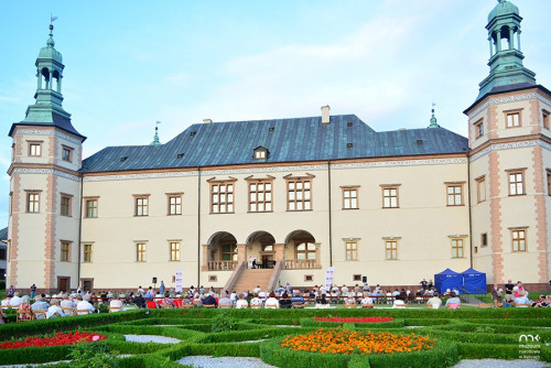 Publiczność zgromadzona w ogrodzie włoskim Muzeum Narodowego w Kielcach słucha artysty grającego na fortepianie