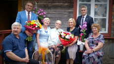 Pamiątkowa fotografia z Aleksandrą Sękowską, najstarszą mieszkanką gminy Łopuszno. Osoby zaproszone na jubileusz trzymają kwiaty