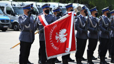 Poczet Sztandarowy. Policjant w maseczce ochronnej trzyma sztandar z napisem ojczyzna i prawo