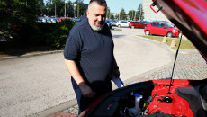 Sekretarz Mariusz Bodo ogląda silnik nowych samochodów z napędem elektrycznym