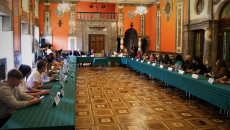 Szeroki plan, zdjęcie sali kominkowej w Wojewódzkim Domu Kultury w Kielcach. Goście z zagranicy siedzą przy stołach