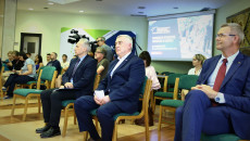 Uczestnicy Konferencji siedzą na krzesłach w sali konferencyjnej. Za uczestnikami ekran i plansza z napisem w języku angielskim European Rover Challenge. Największe wydarzenie kosmiczne w Europie