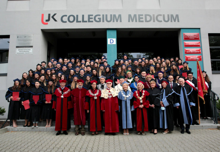 Absolwenci medycyny stoją przed budynkiem Collegium Medicum w Kielcach