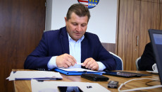 przewodniczący komisji Artur Konarski w ciemny garniturze czyta projekty uchwały