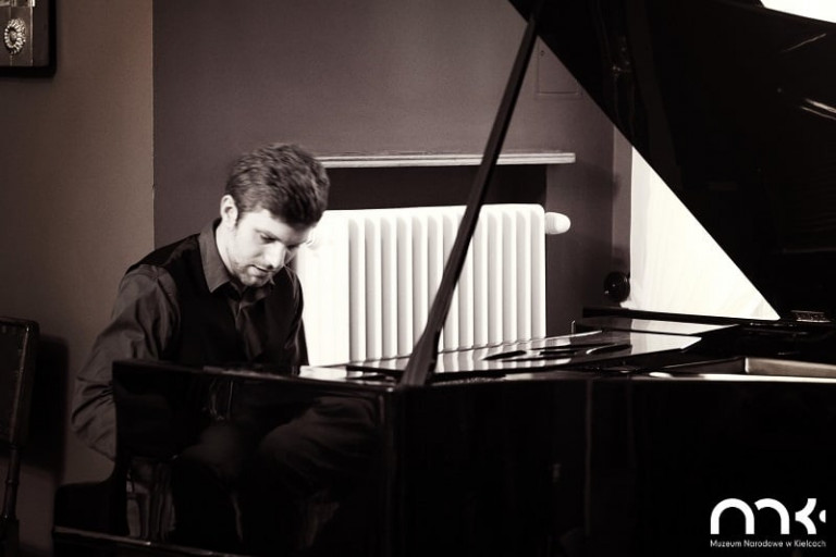 Młody mężczyzna gra na fortepianie. Koncert w Pałacyku