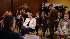 Grupa osób siedzi na krzesłach. Wśród nich Grzegorz Świercz Radny Województwa Świętokrzyskiego. Pomiędzy krzesłami rozstawione na statywach kamery stacji telewizyjnych