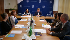 Grupa osób siedzi przy stole na sali konferencyjnej. Spotkanie Zespołu Do Opracowania Strategii Dla Młodzieży