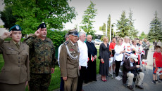 Marszałek Andrzej Bętkowski I Kombatanci Oraz Mieszkańcy stoją na placu. Ubrani w mundury salutują