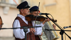 Zdjęcie zbliżenie. Na scenie przed siedzibą WDK w Kielcach grają skrzypek i akordeonista