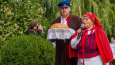 starostowie dożynek w ludowych strojach z bochnem chleba w rękach