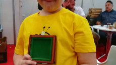 chłopiec prezentuje medal