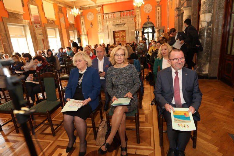 Wicemarszałek Marek Bogusławski siedzi obok pracowników Departamentu Ochrony Zdrowia Urzędu Marszałkowskiego.