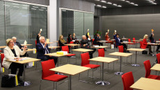 Uczestnicy spotkania głosują poprzez podniesienie rąk