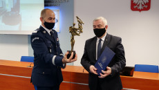 Marszałek Andrzej Bętkowski odbiera z rąk komendanta statuetkę świętokrzyskiego policjanta.