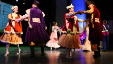 Tancerze tańczą na scenie w historycznych kostiumach