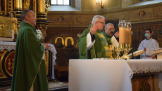 Ksiądz stoi na kościelnej ambonie i głosi kazanie