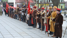 Mężczyźni stoją w rzędzie ubrani w stroje z epoki powstania styczniowego