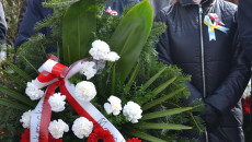 Marek Bogusławski stoi z wiązanką kwiatów w dłoniach