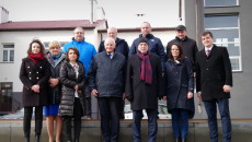 Grupa jedenastu osób, w tym Marek Jońca i Andrzej Bętkowski stoi przed szkołą