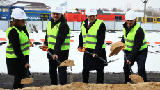 Czwórka osób w białych kaskach, w tym Andrzej Bętkowski i Andrzej Pruś, kopią łopatami w ziemi