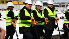 Trójka osób w białych kaskach, w tym Andrzej Bętkowski i Andrzej Pruś, opierają dłonie na łopatach