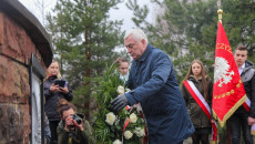 Marszałek Andrzej Bętkowski niesie wieniec pod pomnik Trzech Krzyży