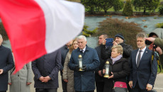 Andrzej Bętkowski wśród grupy osób stojących przed pomnikiem poświęconym rozstrzelanym mieszkańców Huty Szklanej