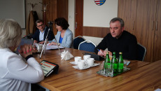 Mężczyzna oraz Dyrektor ROPS Elżbieta Korus i radny Piotr Żołądek siedzą za stołem