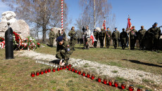 Dziewczyna w mundurze zapala znicze przed monumentem SEN