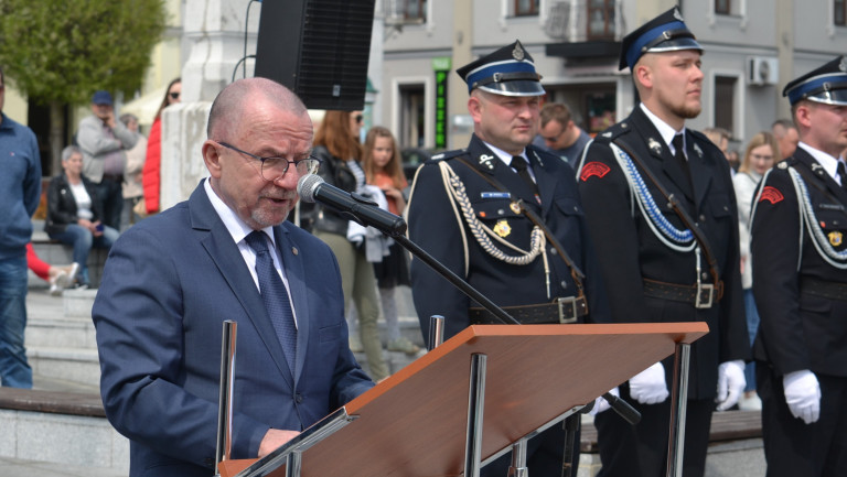 Marek Bogusławski stoi na mównicy na rynku w Malogoszczu i przemawia