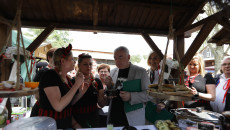 Andrzej Bętkowski próbuje potrawy na jednym ze stoisk kulinarnych w skansenie