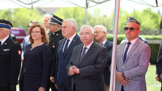 Poseł Krzysztof Lipiec stoi z innymi pod parasolem