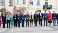 Uczestnicy uroczystości stoja na placu w rzędzie