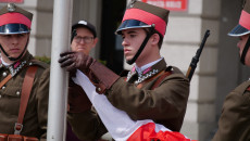 Żołnierz wciąga flagę na maszt