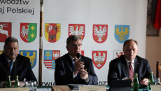 Andrzej Pruś Siedzi Przy Stole Prezydialnym Przemawiając Do Mikrofonu