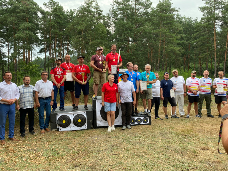 Dziewięciu Zawodników Stoi Na Podium. Wokół Podium Grupa Ludzi