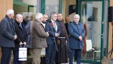 Grupa ludzi stoi przed budynkiem Ośrodka Edukacji Przyrodniczej