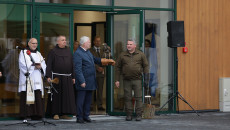 Marszałek Bętkowski z myszołowem na rękawicy stoi w grupie osób przed budynkiem Ośrodka
