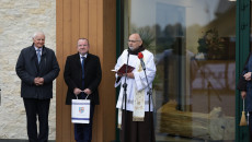 Ksiądz przemawia do mikrofonu przed budynkiem Ośrodka, obok stoją Marek Jońca i Marek Bogusławski
