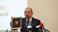 Do mikrofonu przemawia Marek Bogusławski, w ręku trzyma grawerton z herbem województwa